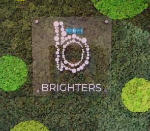 Green moss wall with a company logo (ref. Dubai Design District)